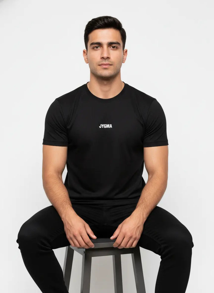 Model seated wearing black Performance T-Shirt for everyday comfort